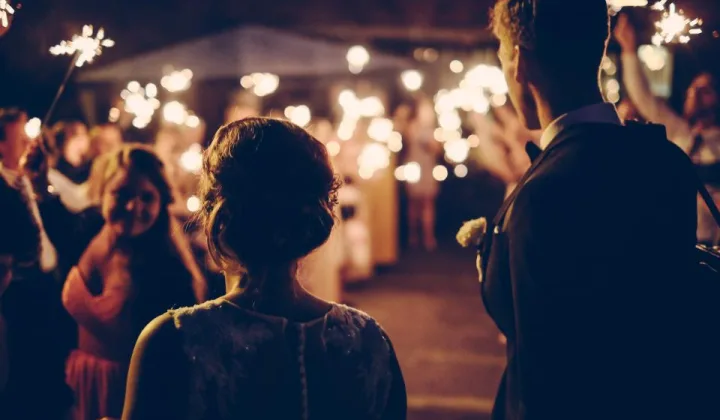 Friends holding sparklers together at a night party